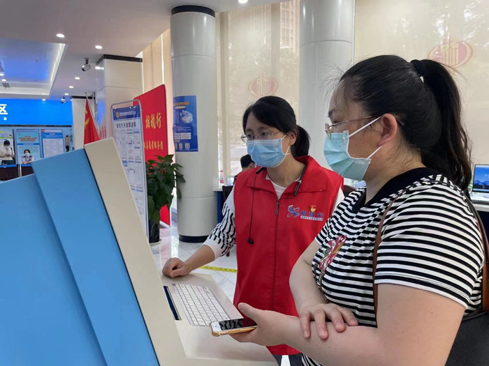 志愿者在自助办税服务终端辅导纳税人操作.jpg